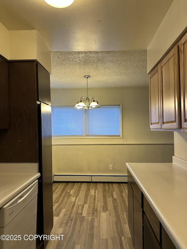 kitchen with light countertops, a textured ceiling, dishwasher, light wood-type flooring, and a chandelier