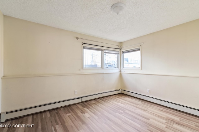 2752 W 42nd Ave Unit 4, Anchorage, AK 99517 - spare room with wood finished floors, a baseboard radiator, and a textured ceiling