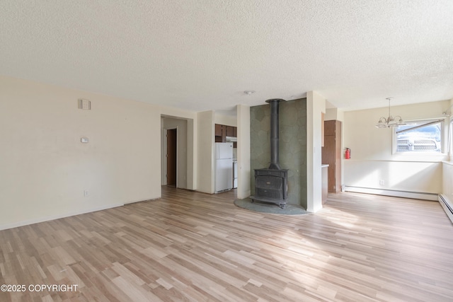 2752 W 42nd Ave Unit 4, Anchorage, AK 99517 - unfurnished living room featuring a textured ceiling, light wood-type flooring, a wood stove, baseboard heating, and a chandelier