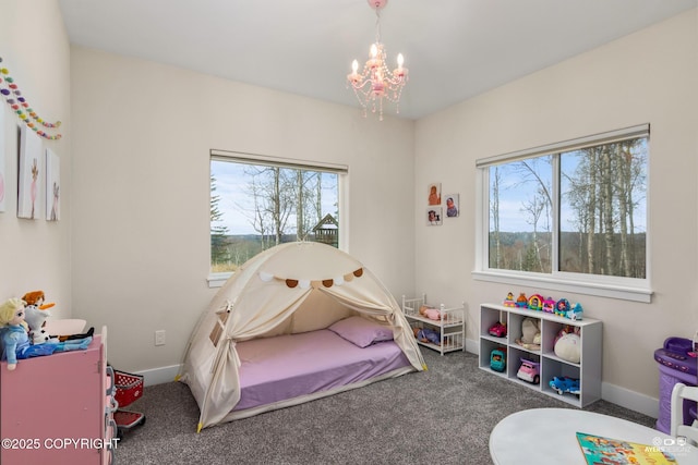 carpeted bedroom featuring baseboards and a chandelier