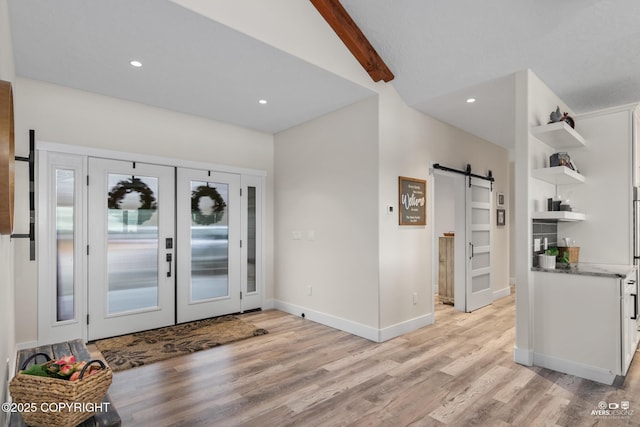 entrance foyer with beamed ceiling, recessed lighting, a barn door, french doors, and light wood finished floors