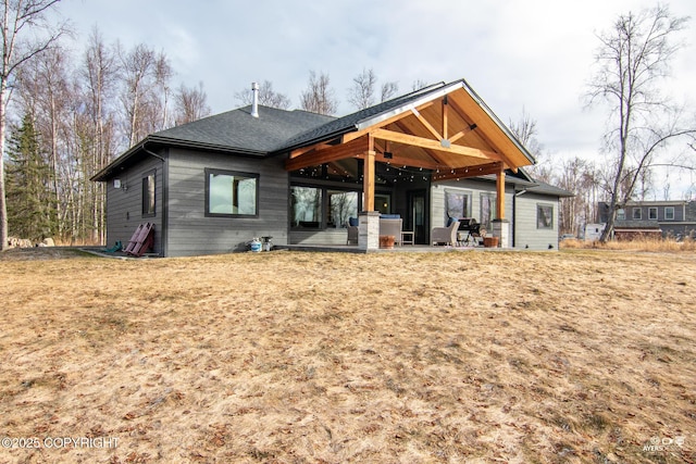 back of house featuring roof with shingles and a patio area