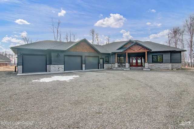 view of front of property with roof with shingles, french doors, driveway, stone siding, and an attached garage