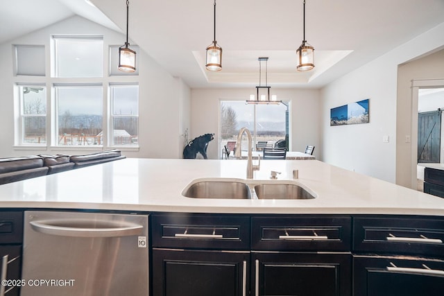 kitchen with a sink, dishwasher, dark cabinets, and light countertops