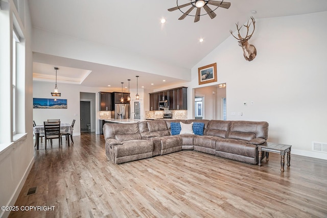 living room featuring visible vents, baseboards, and wood finished floors