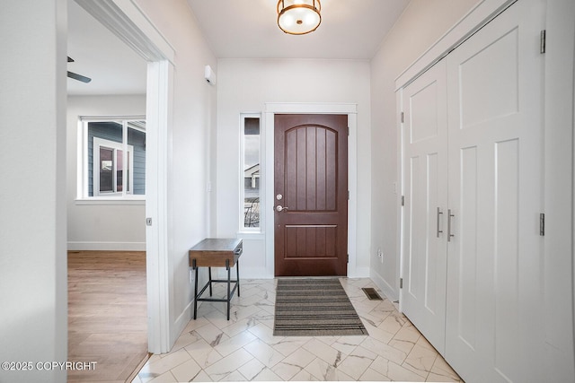 foyer featuring visible vents, baseboards, and marble finish floor