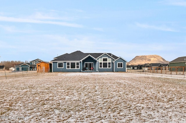 view of front of house with a mountain view and fence