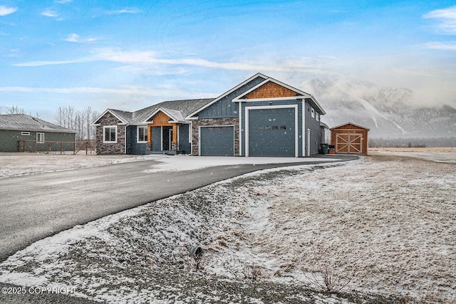 view of front facade featuring stone siding, driveway, and an attached garage