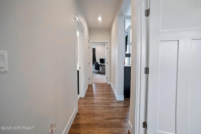 hallway with baseboards and wood finished floors