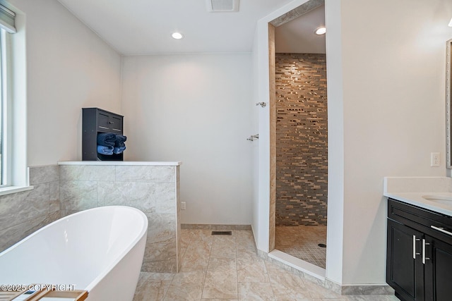 full bath with vanity, a soaking tub, visible vents, and a stall shower