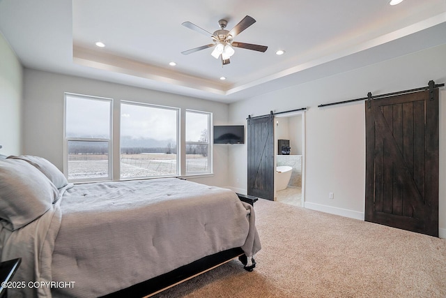 carpeted bedroom with a tray ceiling, a barn door, baseboards, and recessed lighting