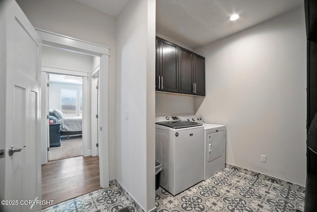 laundry room with light tile patterned floors, baseboards, cabinet space, and washing machine and clothes dryer