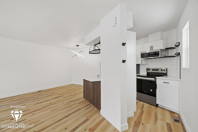 kitchen with light wood-type flooring, visible vents, backsplash, stainless steel appliances, and white cabinets