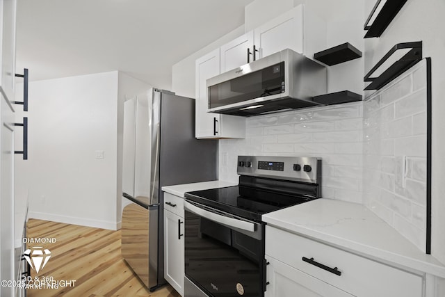 kitchen featuring light wood-type flooring, stainless steel appliances, decorative backsplash, and white cabinetry