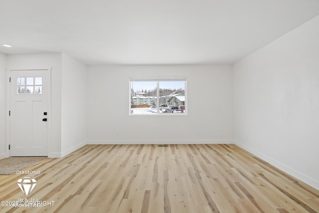 entrance foyer featuring light wood-type flooring, baseboards, and a healthy amount of sunlight