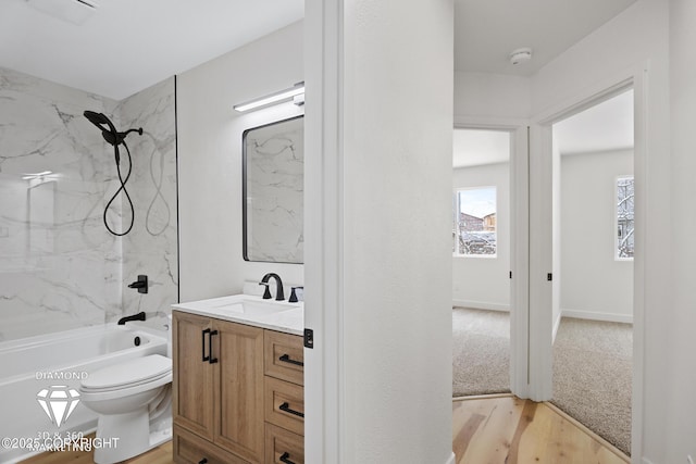 full bathroom featuring vanity, wood finished floors, baseboards, shower / tub combination, and toilet