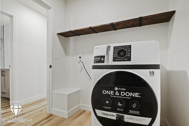 laundry area featuring laundry area, washer / clothes dryer, light wood-type flooring, and baseboards