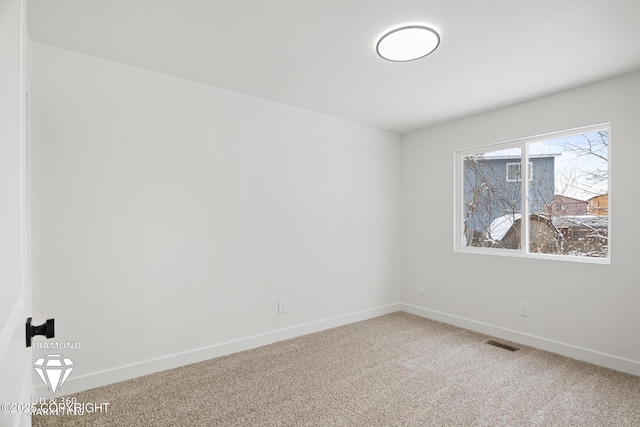 unfurnished room with visible vents, light colored carpet, and baseboards