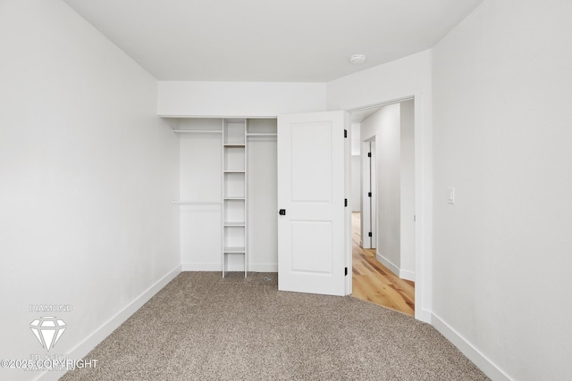 unfurnished bedroom with a closet, baseboards, and carpet floors