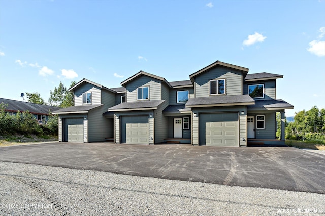 view of front of home with an attached garage, driveway, and a shingled roof