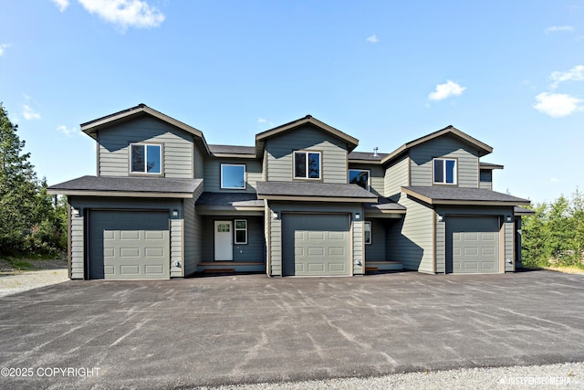 view of front of property featuring aphalt driveway, an attached garage, and a shingled roof