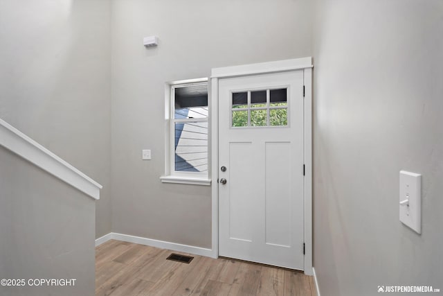 entrance foyer with light wood finished floors, visible vents, and baseboards