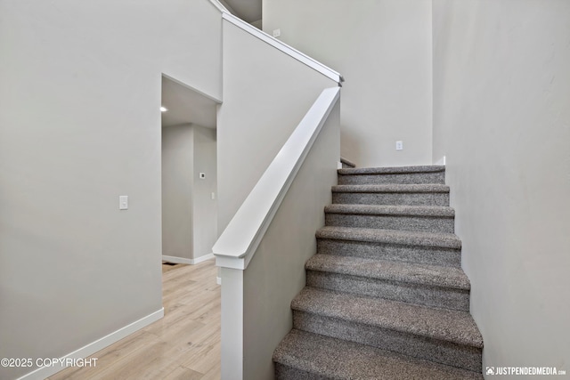 stairs with wood finished floors and baseboards