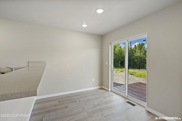 spare room featuring recessed lighting, visible vents, baseboards, and light wood-style flooring