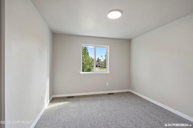 spare room with visible vents, carpet floors, and baseboards