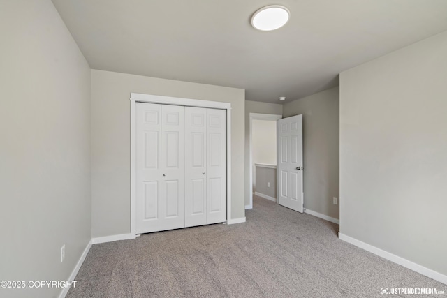 unfurnished bedroom with a closet, baseboards, and carpet floors