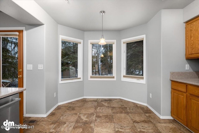 unfurnished dining area with visible vents, baseboards, a wealth of natural light, and stone finish flooring