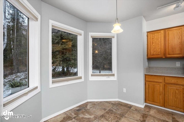 unfurnished dining area with visible vents, stone finish floor, and baseboards