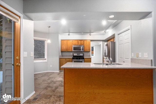 kitchen featuring visible vents, brown cabinets, a sink, stainless steel appliances, and a peninsula