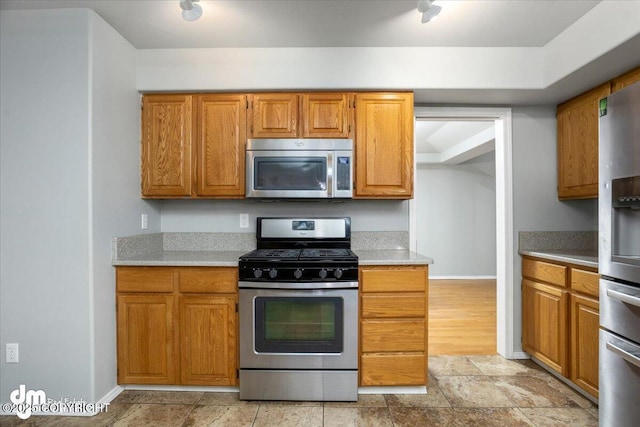 kitchen with brown cabinets, stainless steel appliances, and light countertops