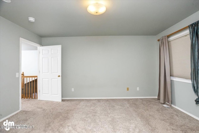 unfurnished room with baseboards and carpet flooring