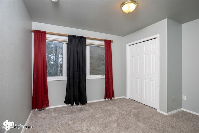 unfurnished bedroom featuring visible vents, baseboards, a closet, and carpet floors