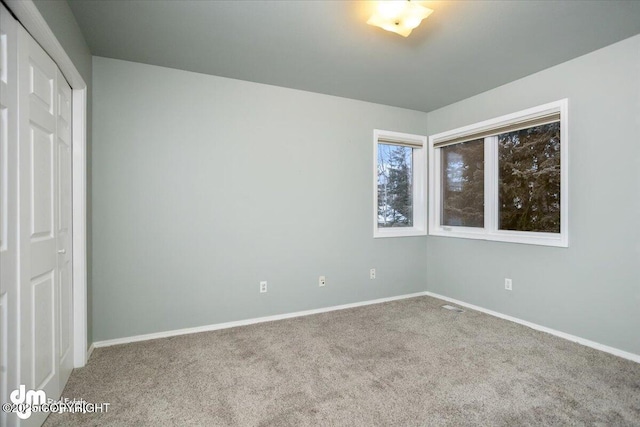 unfurnished bedroom featuring a closet, baseboards, and carpet