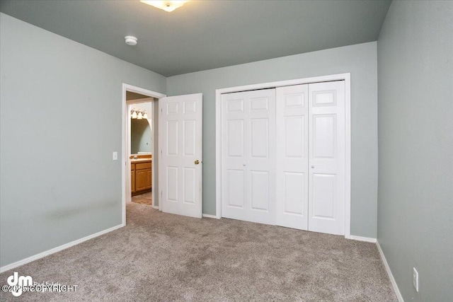 unfurnished bedroom with a closet, baseboards, and carpet flooring