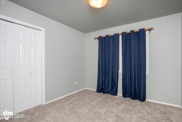 carpeted empty room with baseboards