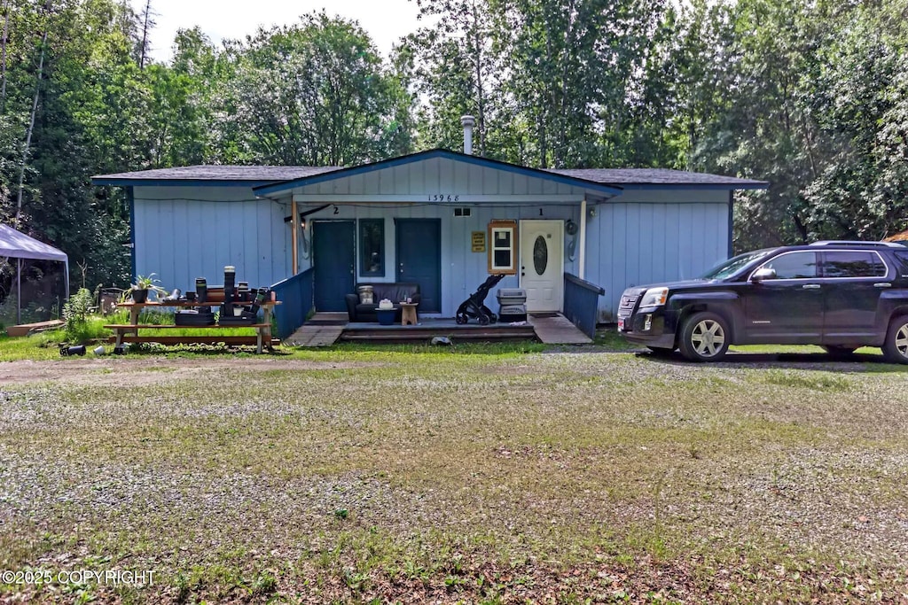 13968 W Holly Loop, Big Lake, AK 99623 - view of front of home featuring a porch, a front lawn, and view of wooded area