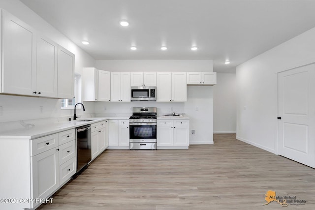 kitchen featuring stainless steel appliances, light wood-style flooring, and white cabinets