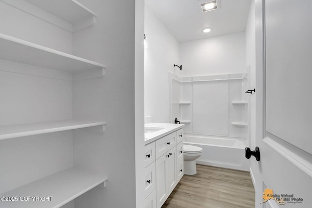 bathroom with visible vents, toilet, wood finished floors, bathtub / shower combination, and vanity