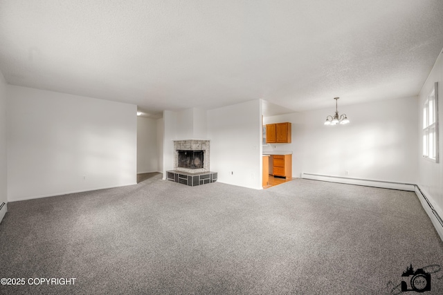 unfurnished living room featuring a textured ceiling, light carpet, a notable chandelier, and a tile fireplace