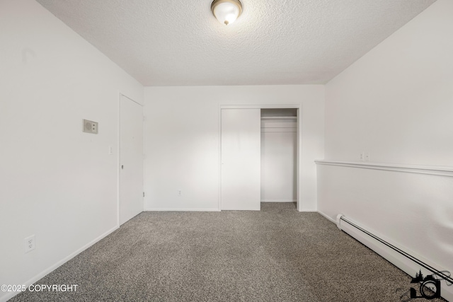 unfurnished bedroom featuring a baseboard heating unit, baseboards, carpet flooring, a closet, and a textured ceiling