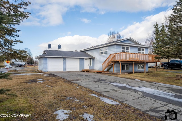 view of front of property with an attached garage, stairs, a front yard, a deck, and driveway