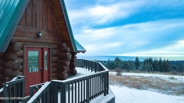 snow covered property entrance with log exterior