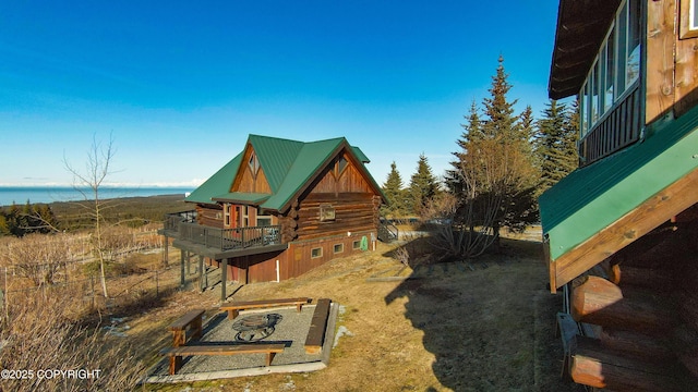 view of side of property featuring log siding and metal roof