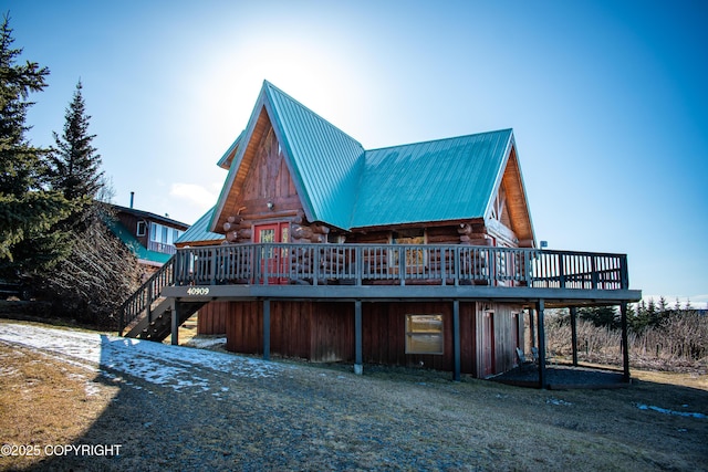 rear view of property featuring metal roof, a deck, log exterior, and stairway