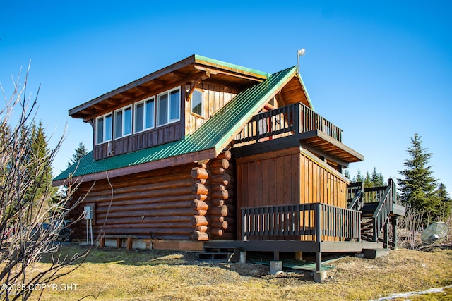 view of property exterior featuring log siding, metal roof, and a wooden deck