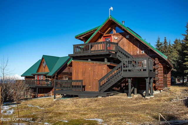 rear view of house with stairway, log siding, metal roof, and a wooden deck